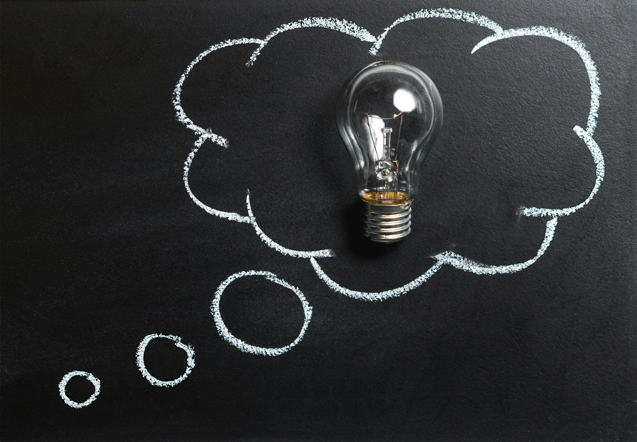 light bulb A light bulb sitting on top of a chalkboard.