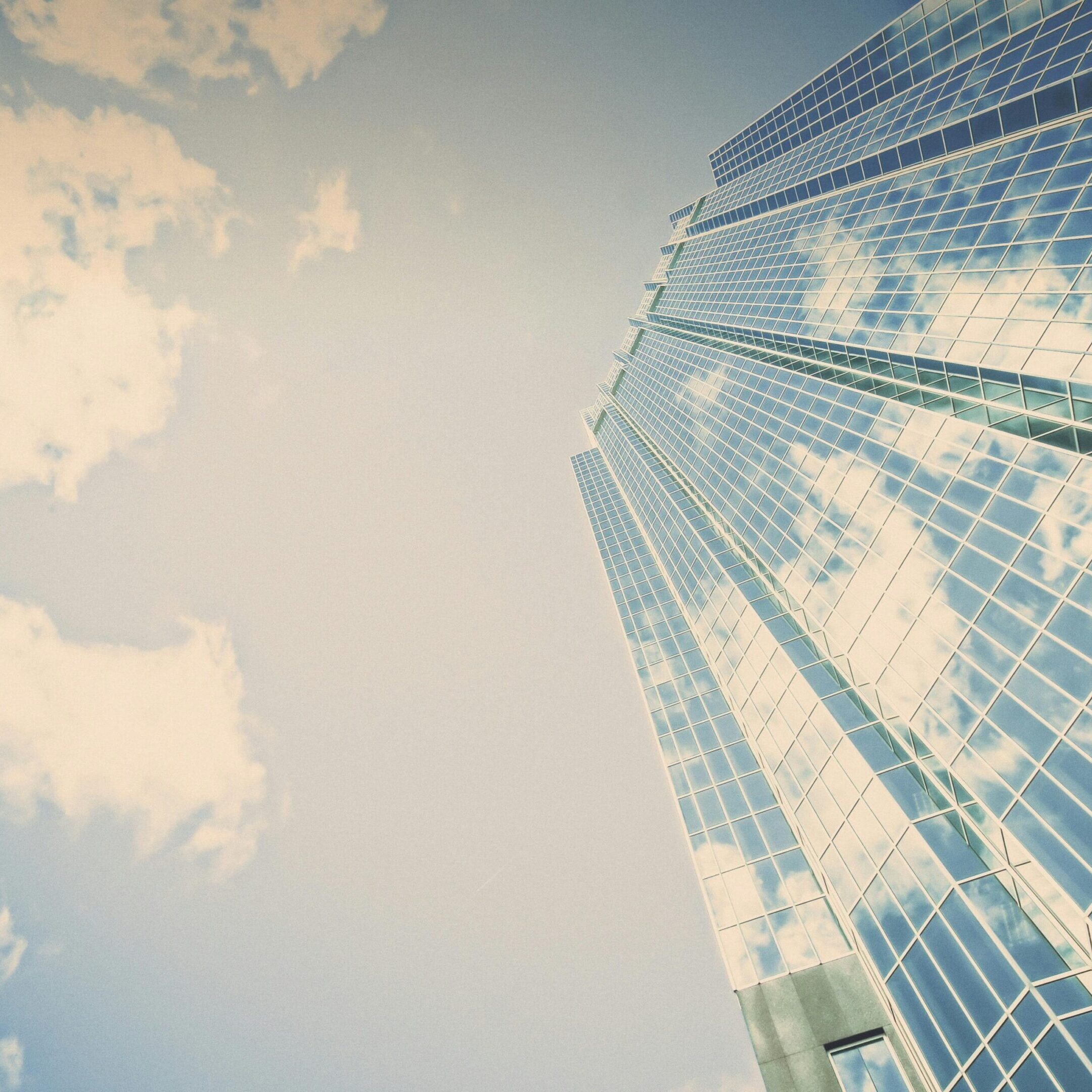 Building A view of the sky from below a skyscraper.