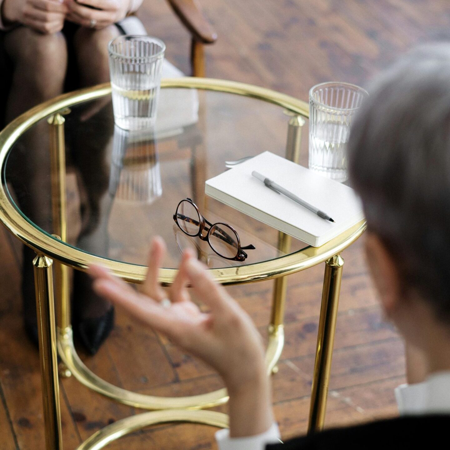 coaching A person sitting at a table with glasses and papers